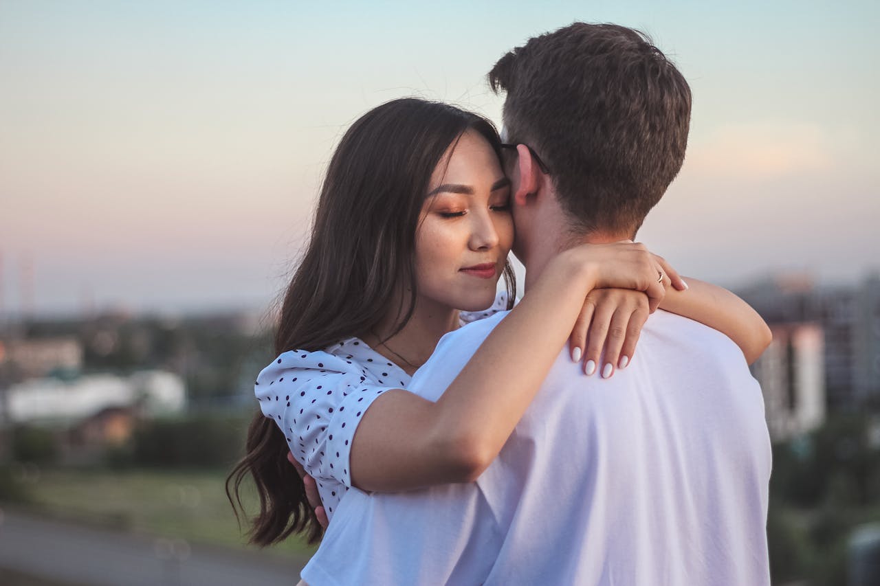 A tender embrace between a couple at sunset, showcasing love and intimacy.